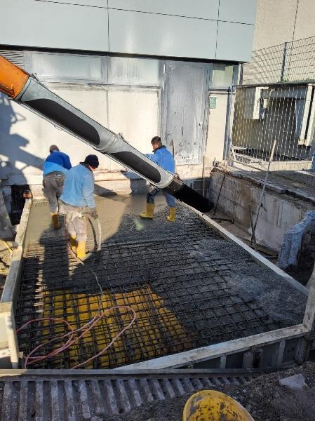Hier sieht man wie Beton auf die Decke vom alten Kamin gegeben wird.
