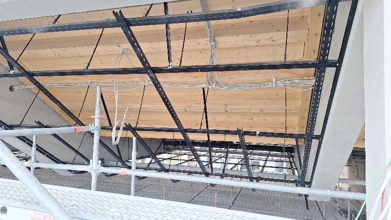 Hier sieht man die Schwimmhallendecke von unten mit der Vorbereitung für die abgehängte Decke in der Schwimmhalle und Strom- und Datenkabel