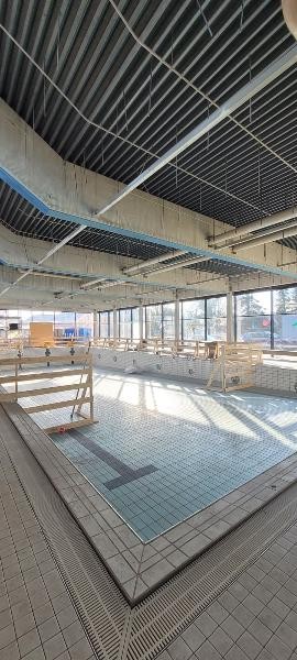 Halle ohne Decke Hier sieht man das leere Becken mit einer Absturtzsicherung und der fehlenden Deckenverkleidung